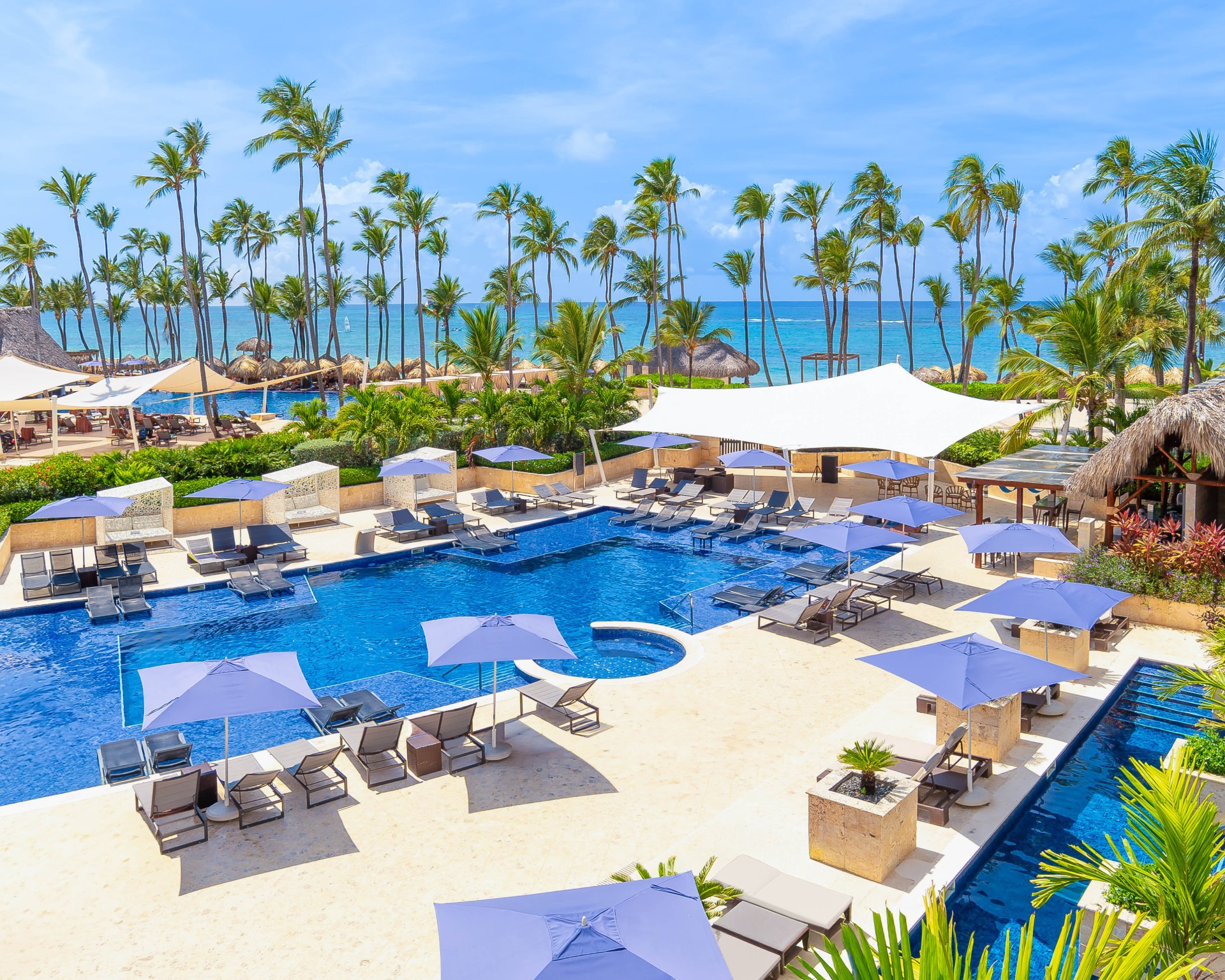 a pool with umbrellas and chairs and palm trees