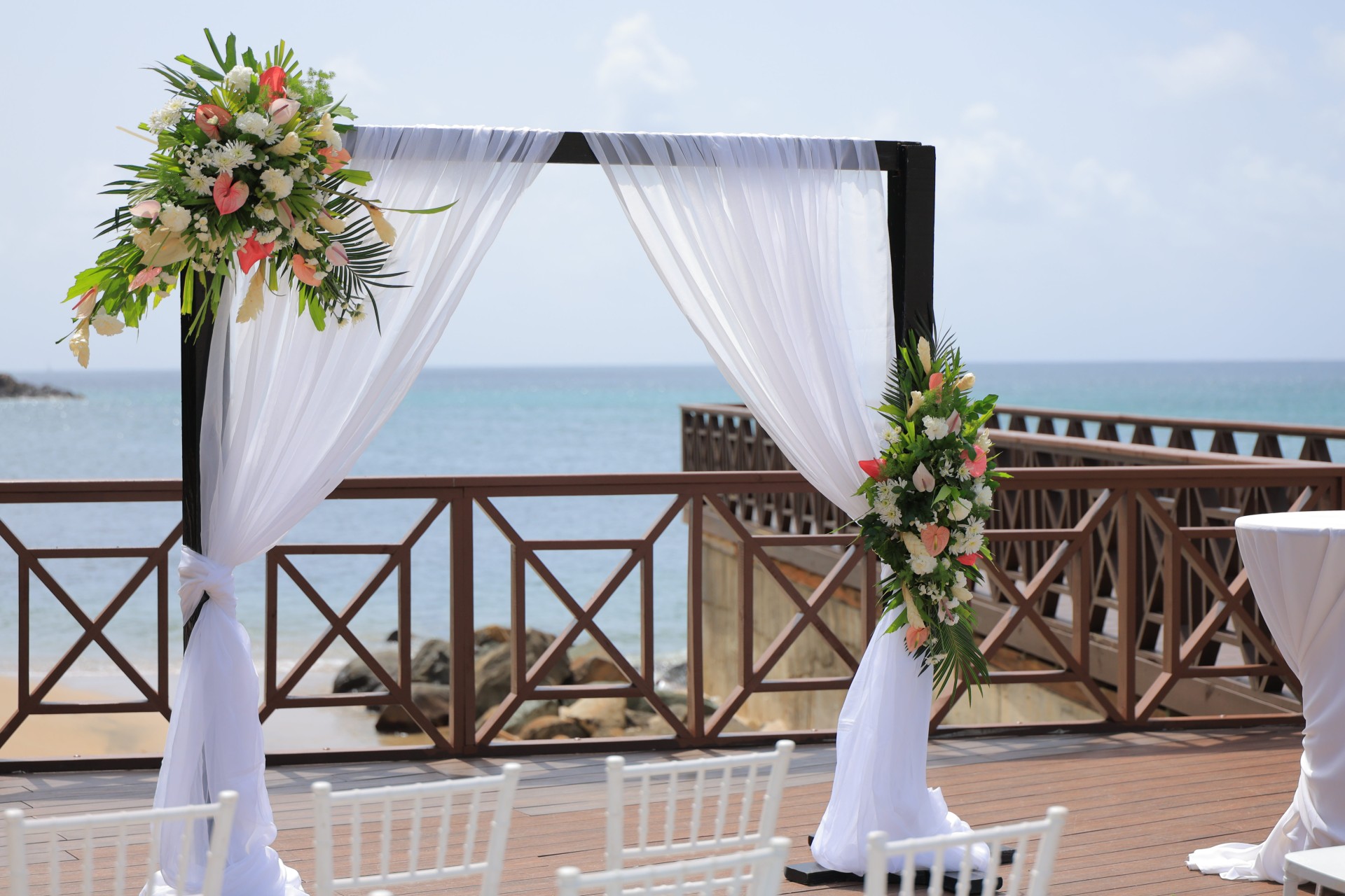 a wedding ceremony set up with white chairs and flowers