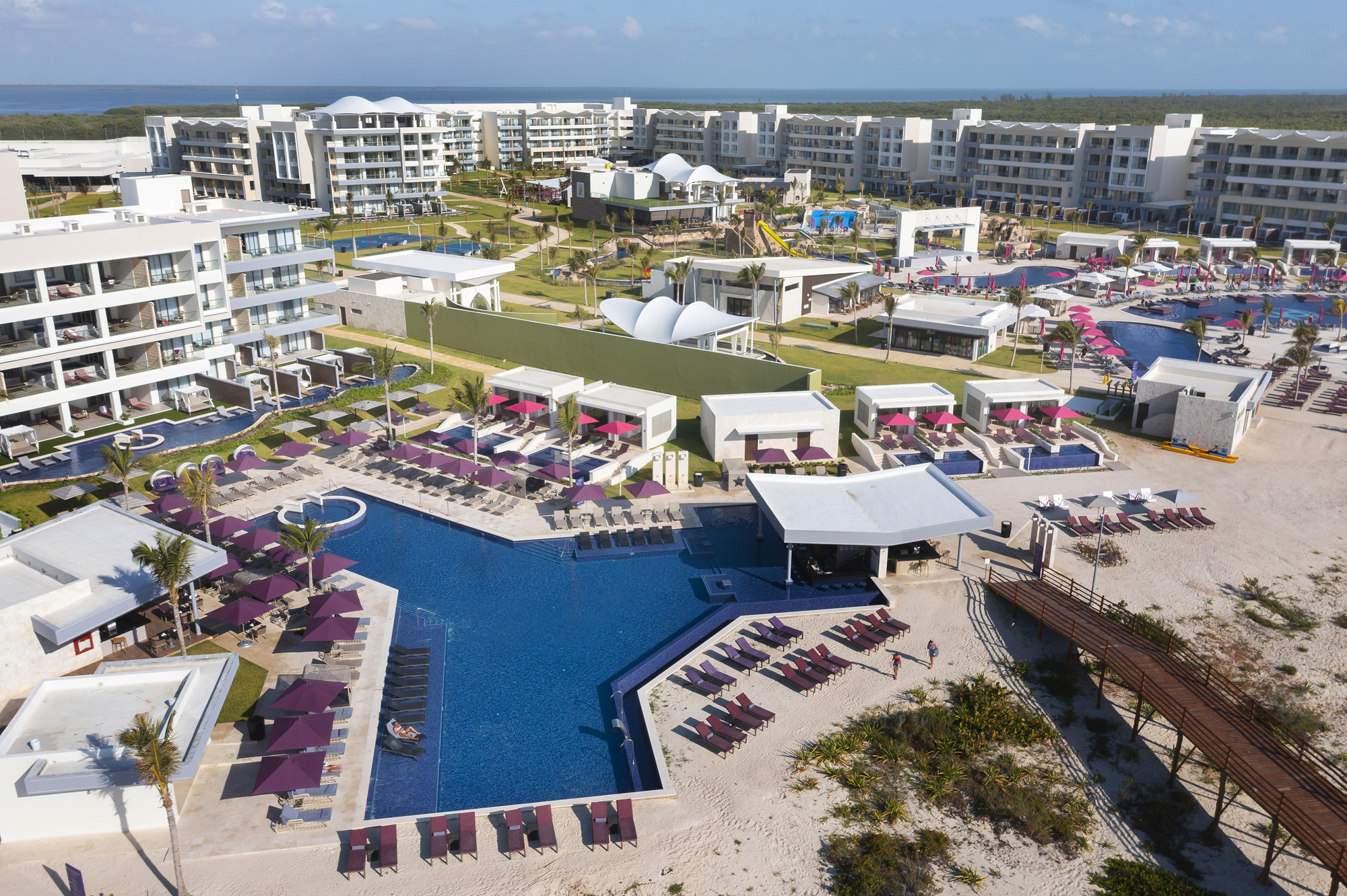 a swimming pool and buildings with umbrellas