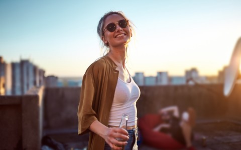 Woman on terrace, holding beer