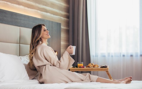 Woman enjoying room service, breakfast in bed