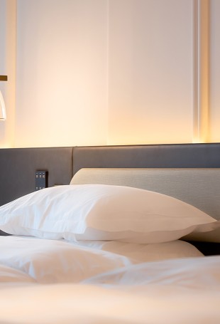 a bed with white sheets and pillows