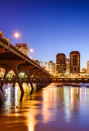 a bridge over a body of water with a city in the background