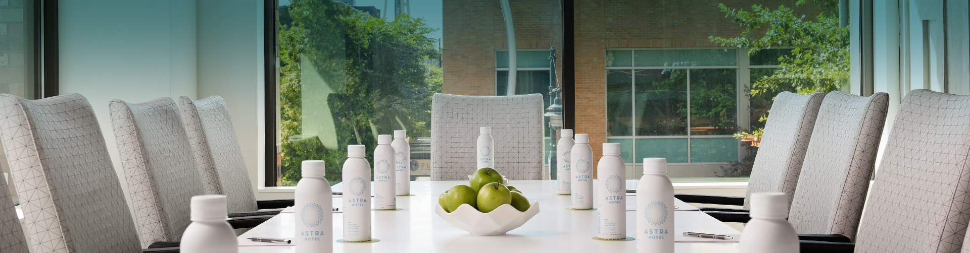a group of white bottles on a table with apples in front of them