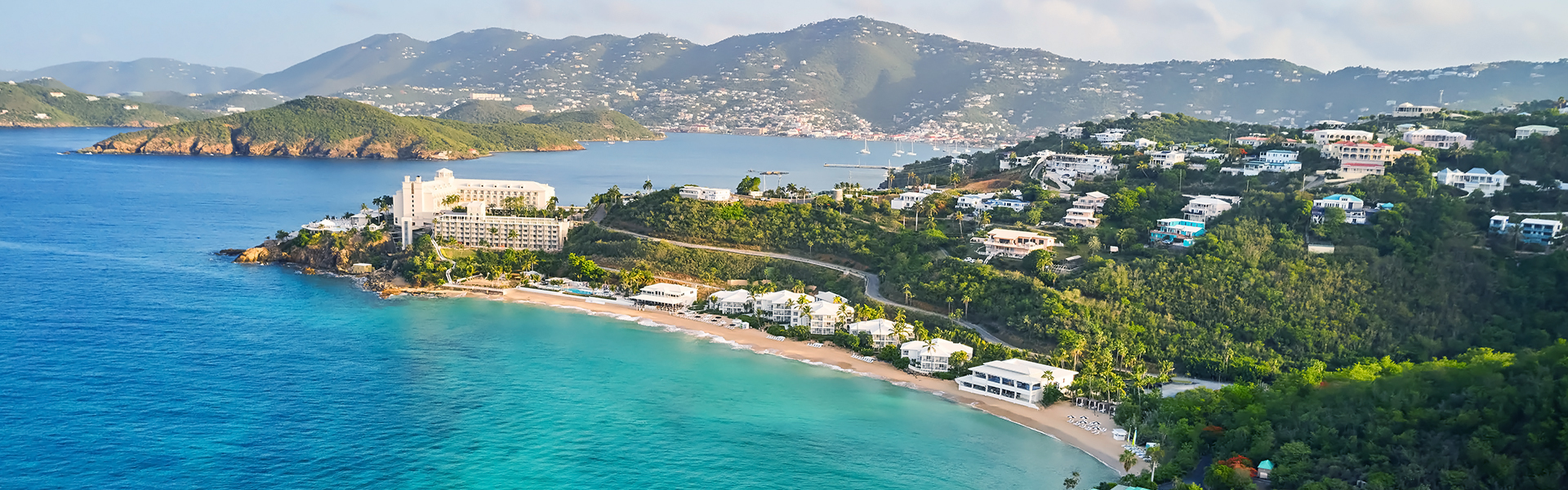 a beach with buildings and a body of water