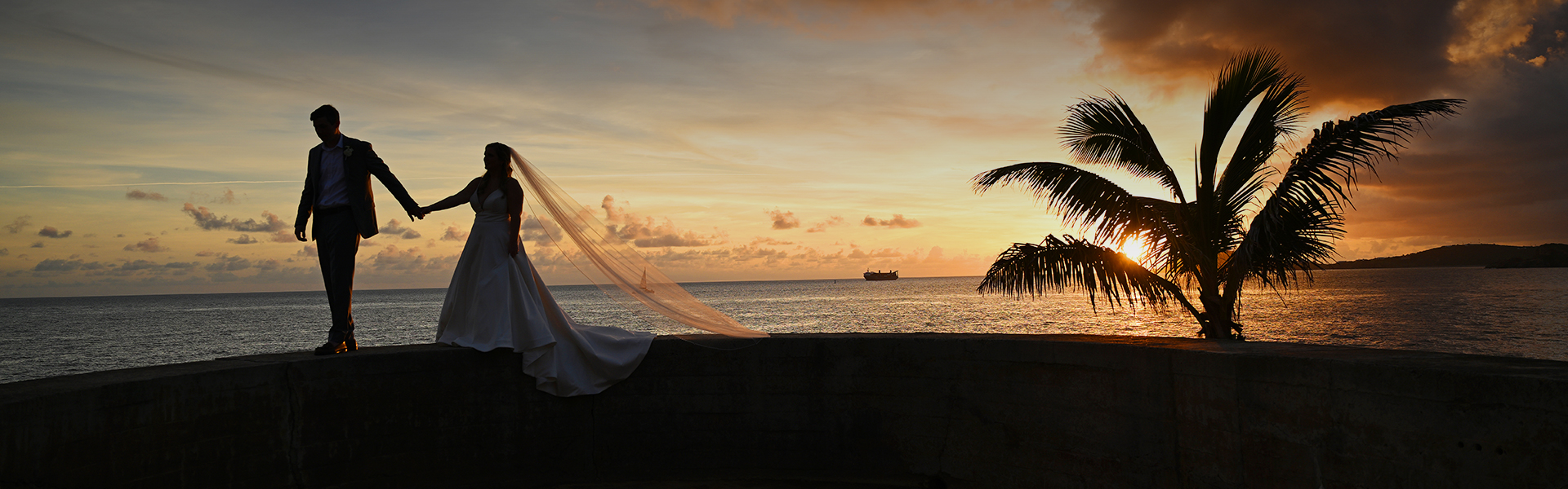 a white tent with a net over a body of water with a boat in the background
