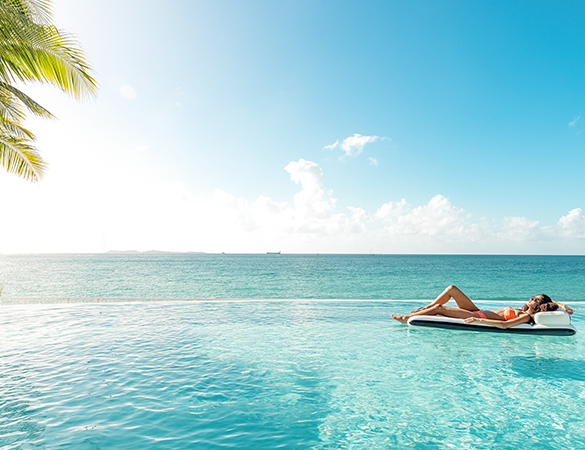a woman lying on a floating board in a pool