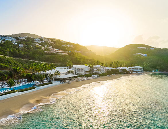 a beach with buildings and a pool on the side