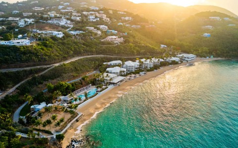 a beach with buildings and a body of water