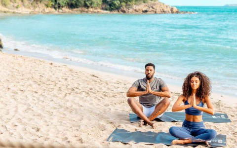 a man and woman sitting on the beach