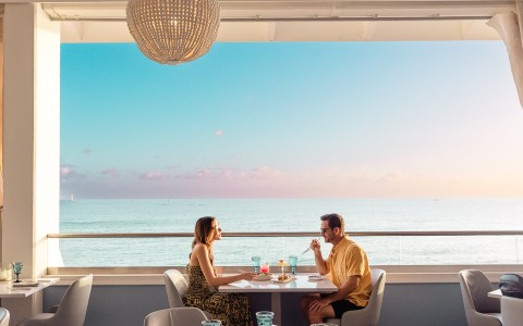 a man and woman sitting at a table with food on it