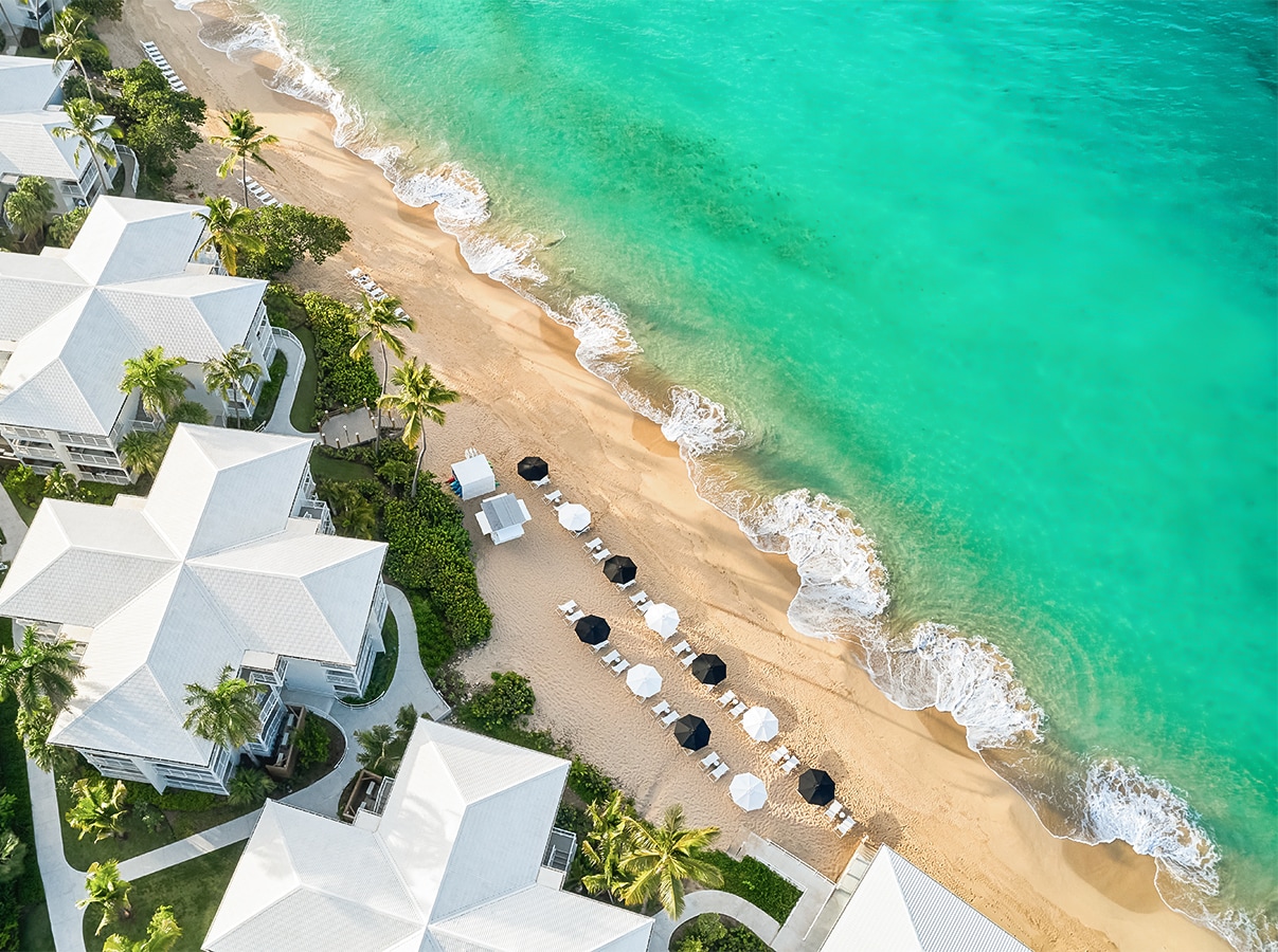 a beach with white buildings and umbrellas