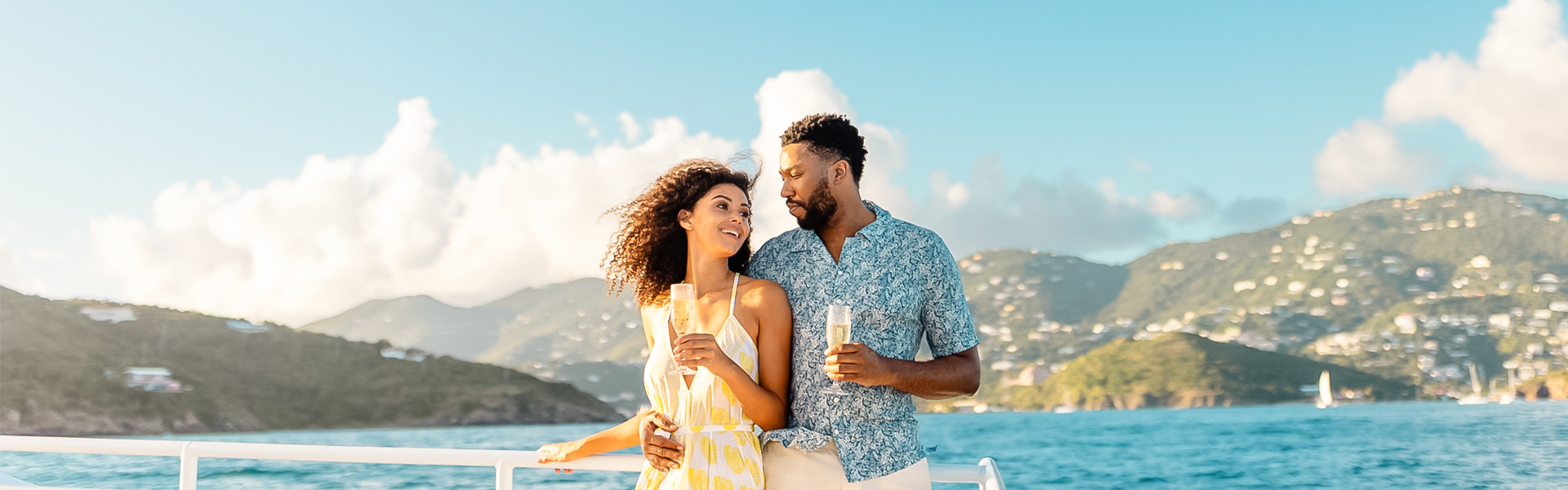 a man and woman holding drinks on a boat