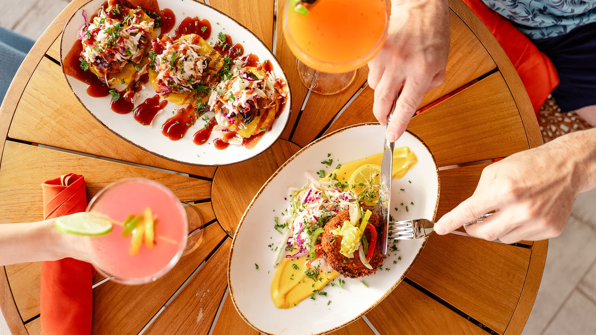a person holding a fork and knife to a plate of food