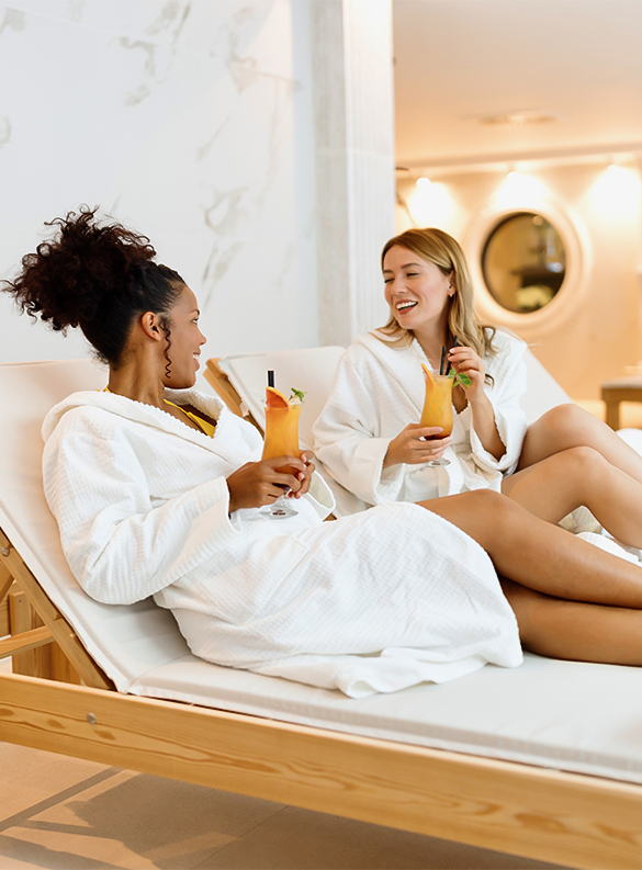 a group of women in bathrobes holding drinks