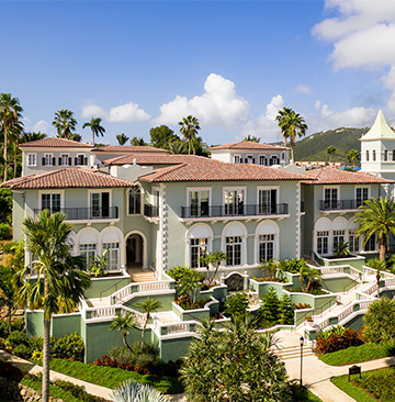 a large building with a large balcony and a garden with Rambagh Palace in the background