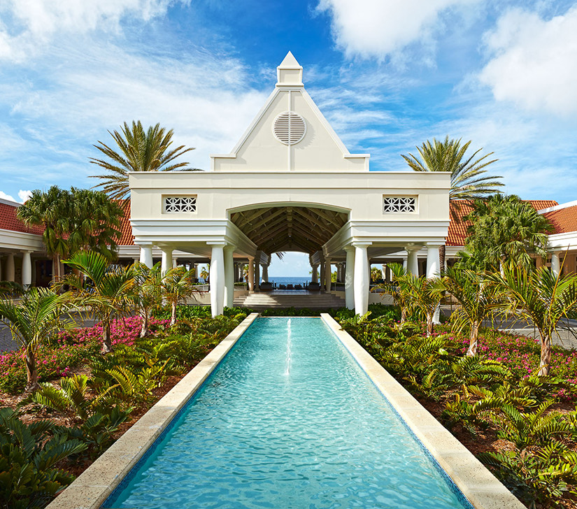 a pool in front of a white building with a dome roof