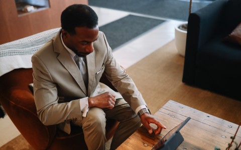 a man sitting in a chair using a tablet