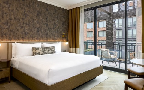 a bed with a glass door and a chair outside