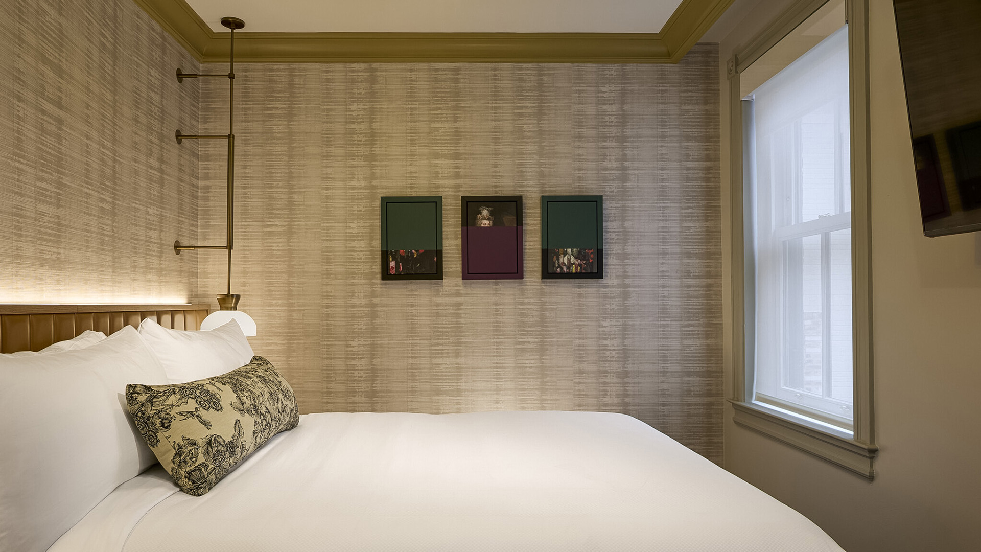 a bed with a lamp and a lamp on the wall