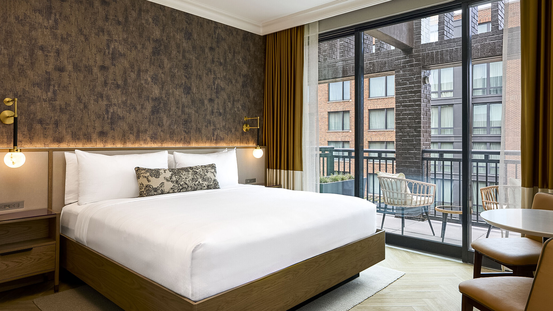 a bed in a room with a balcony and glass doors