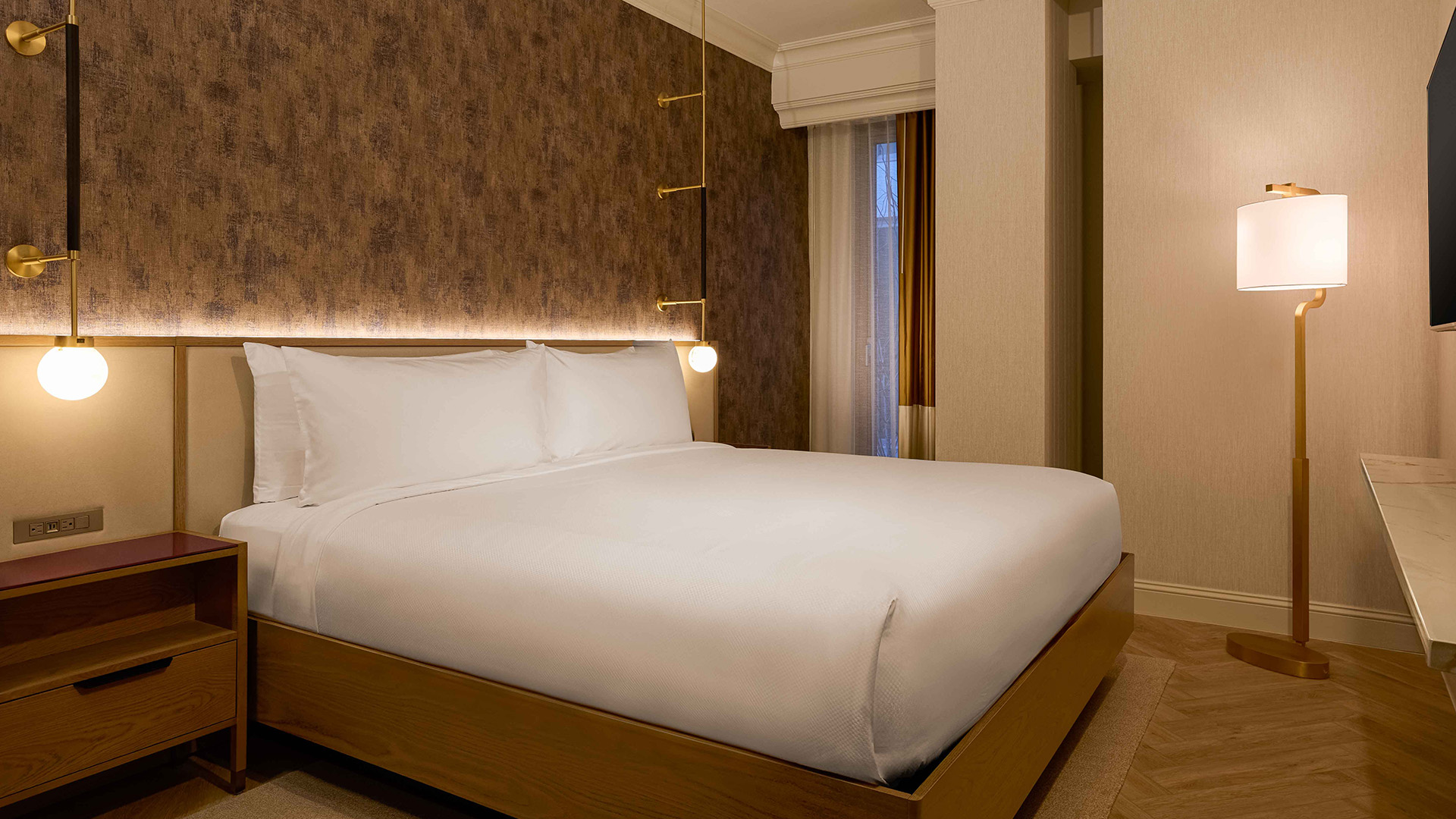 a bed with white sheets and a lamp