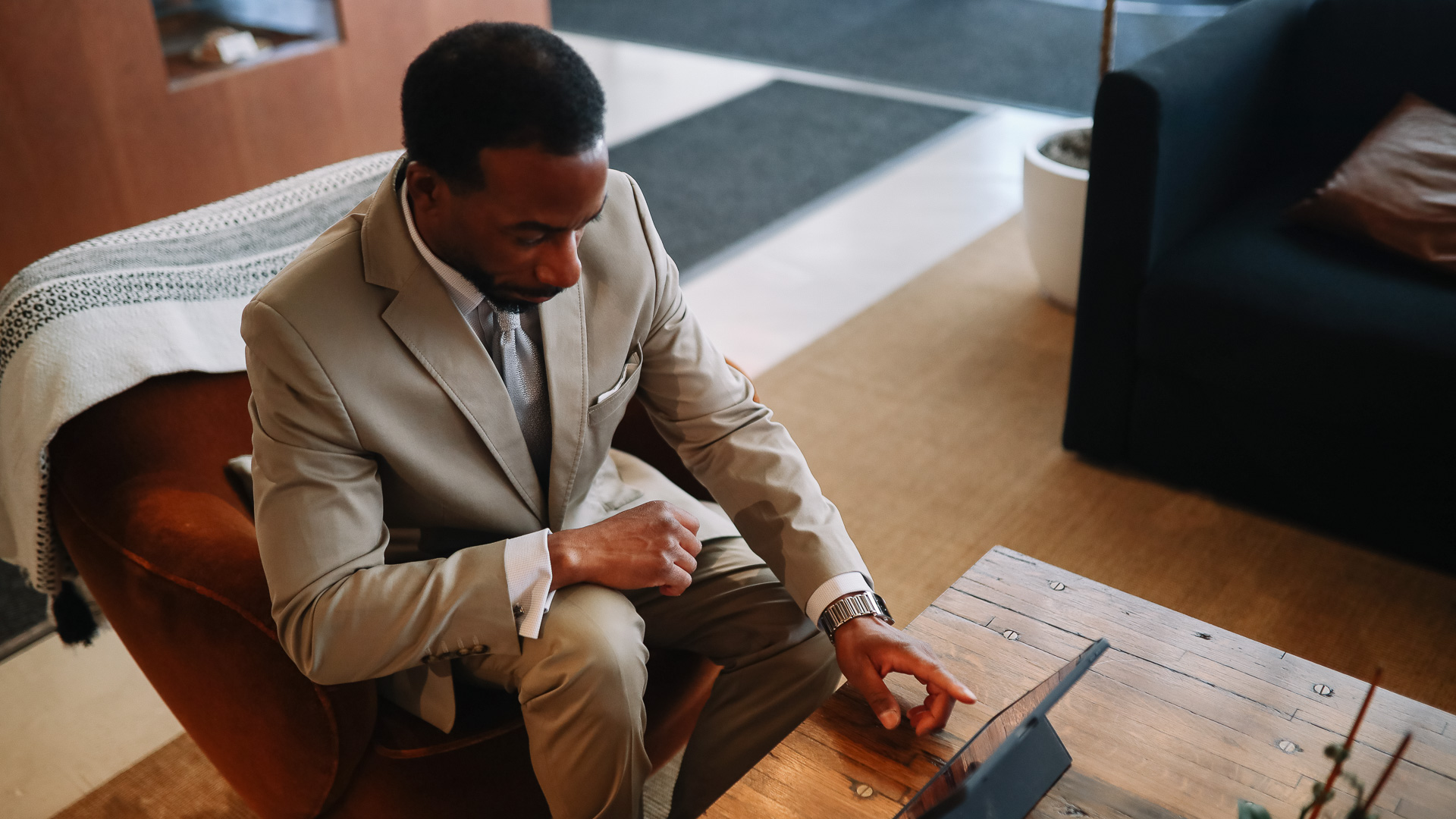 a man sitting in a chair using a tablet