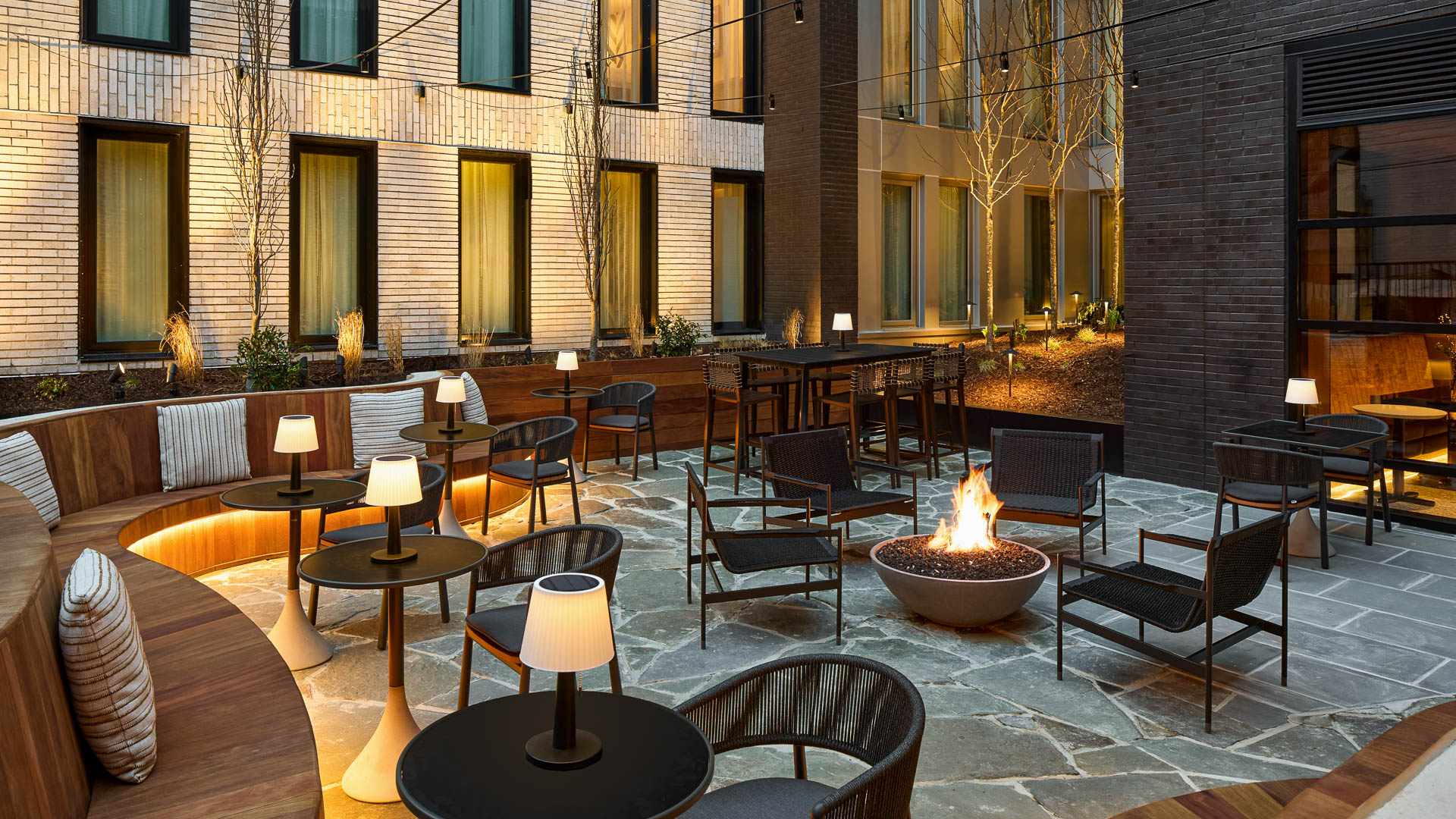 a patio with chairs and tables and a fire pit