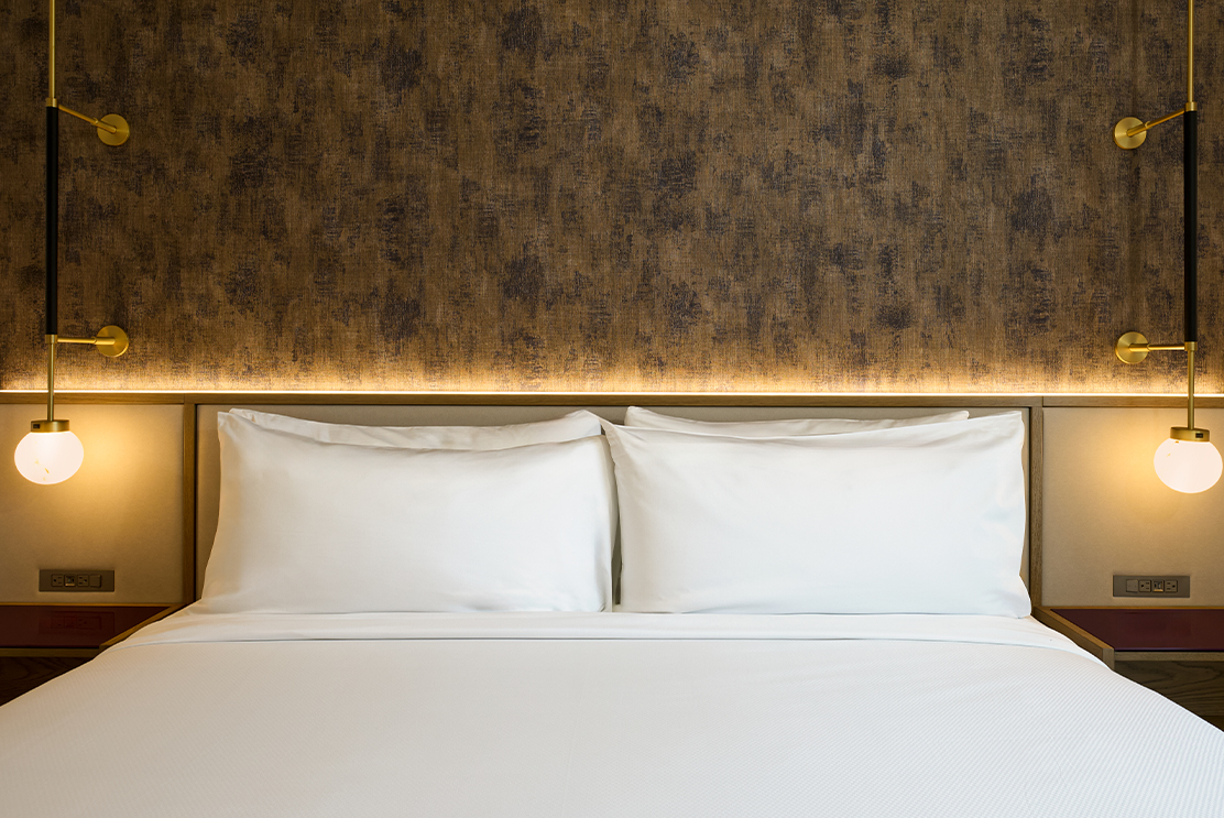 a bed with white sheets and pillows