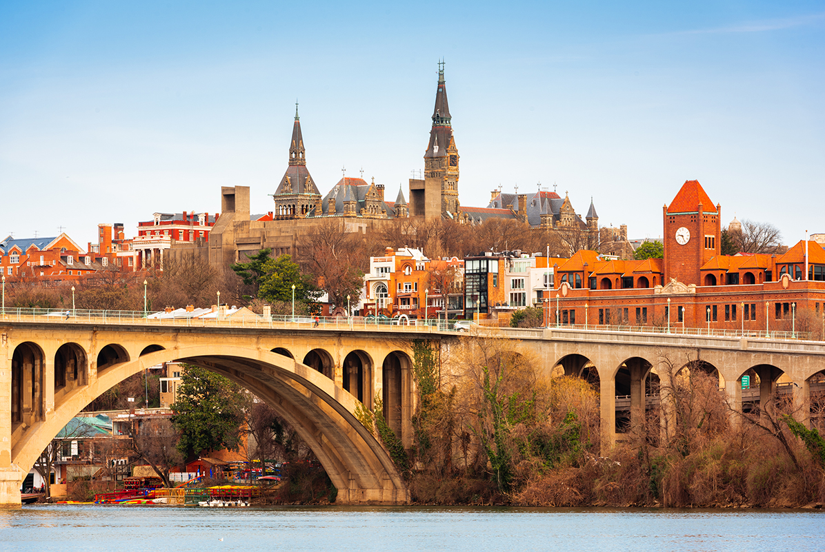 a bridge over a river with a large building in the background