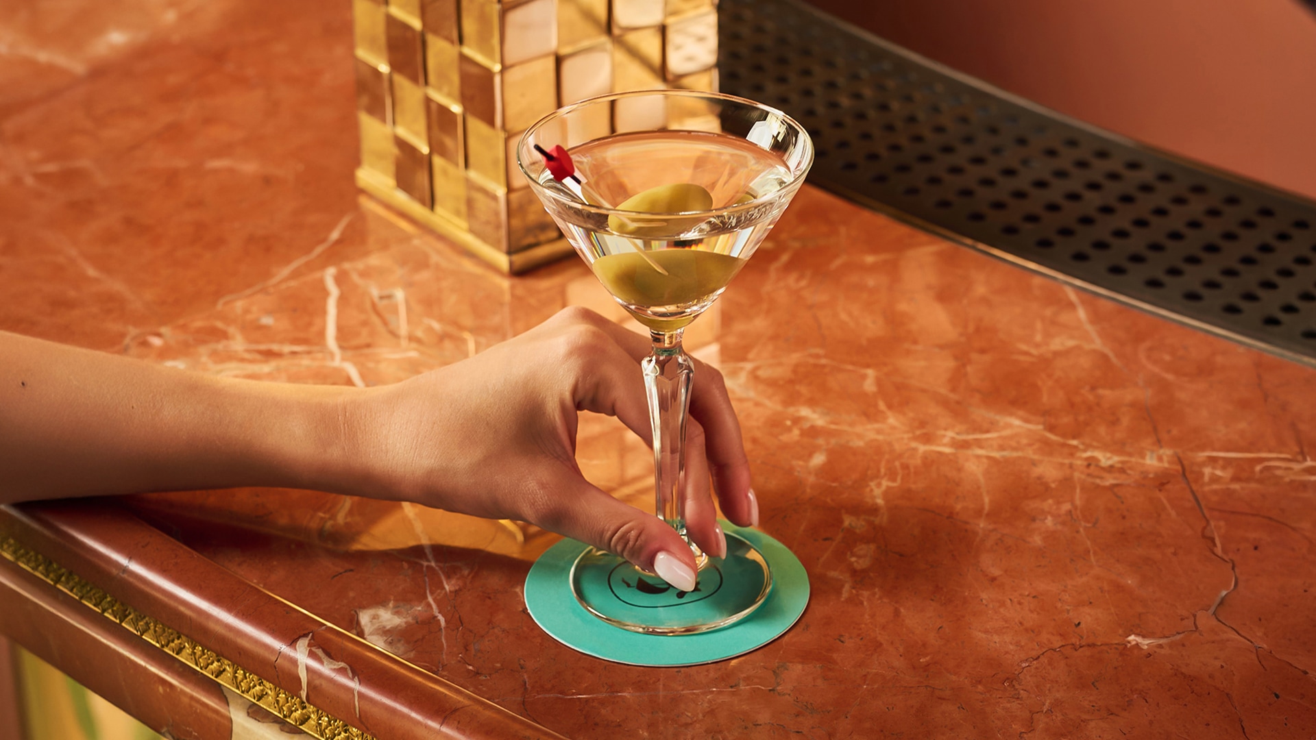 a hand holding a martini glass