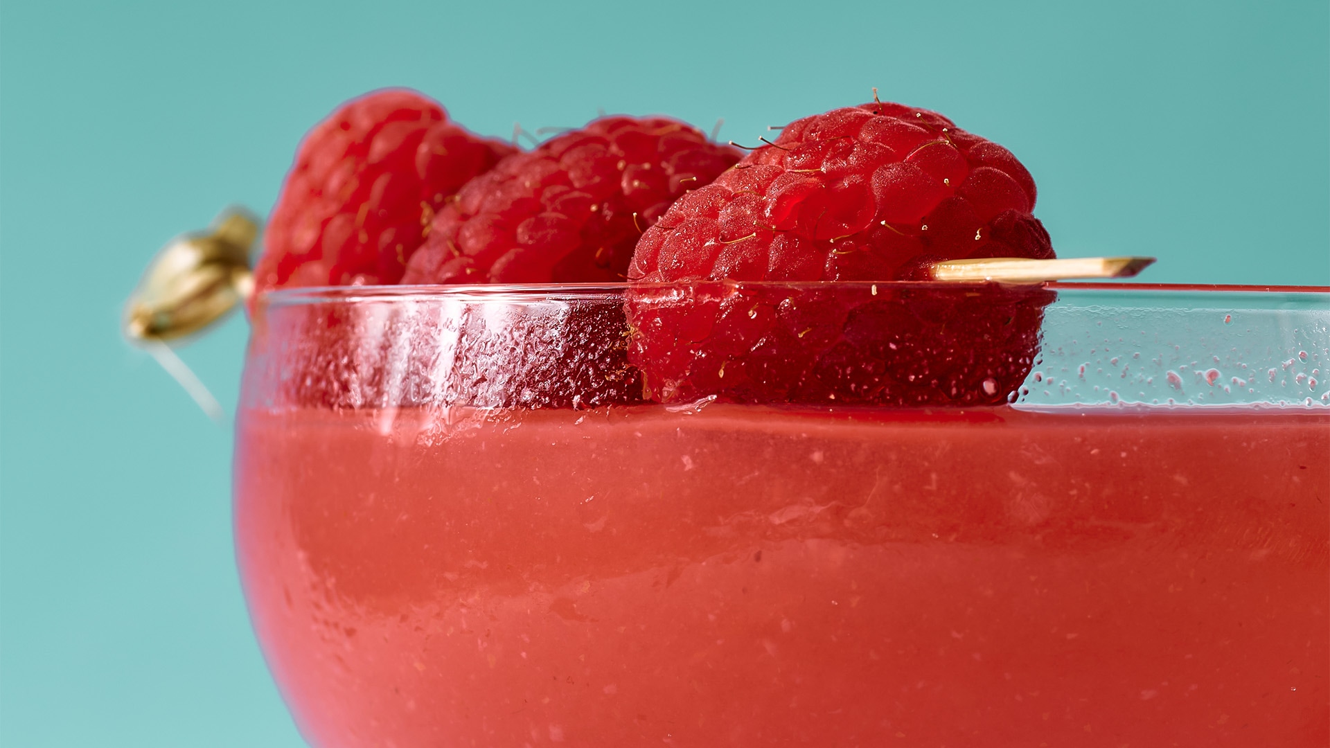 a close up of a drink with raspberries