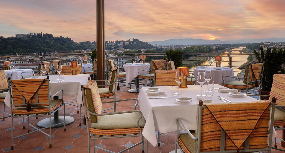a table set up on a patio with a view of a city and mountains