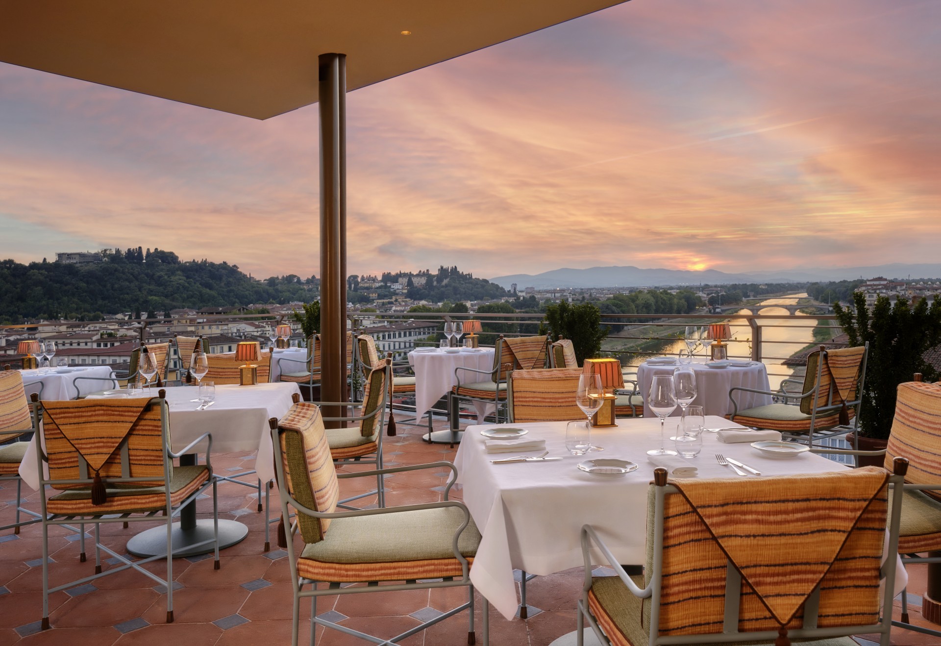 a restaurant with tables and chairs overlooking a city