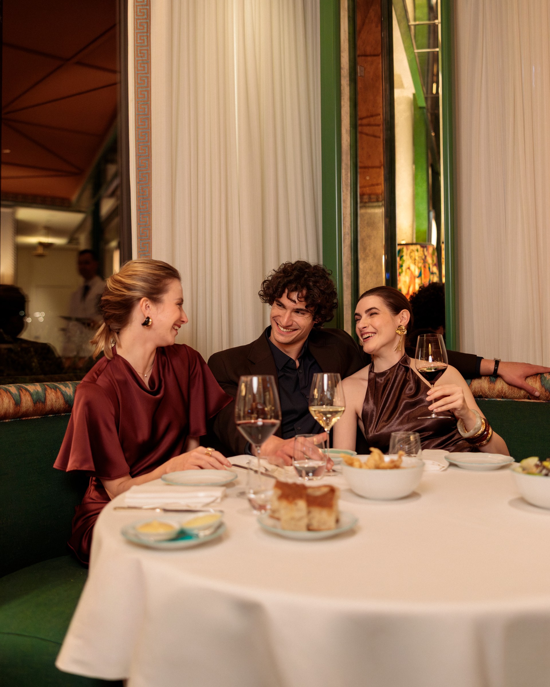 a group of people sitting at a table with food