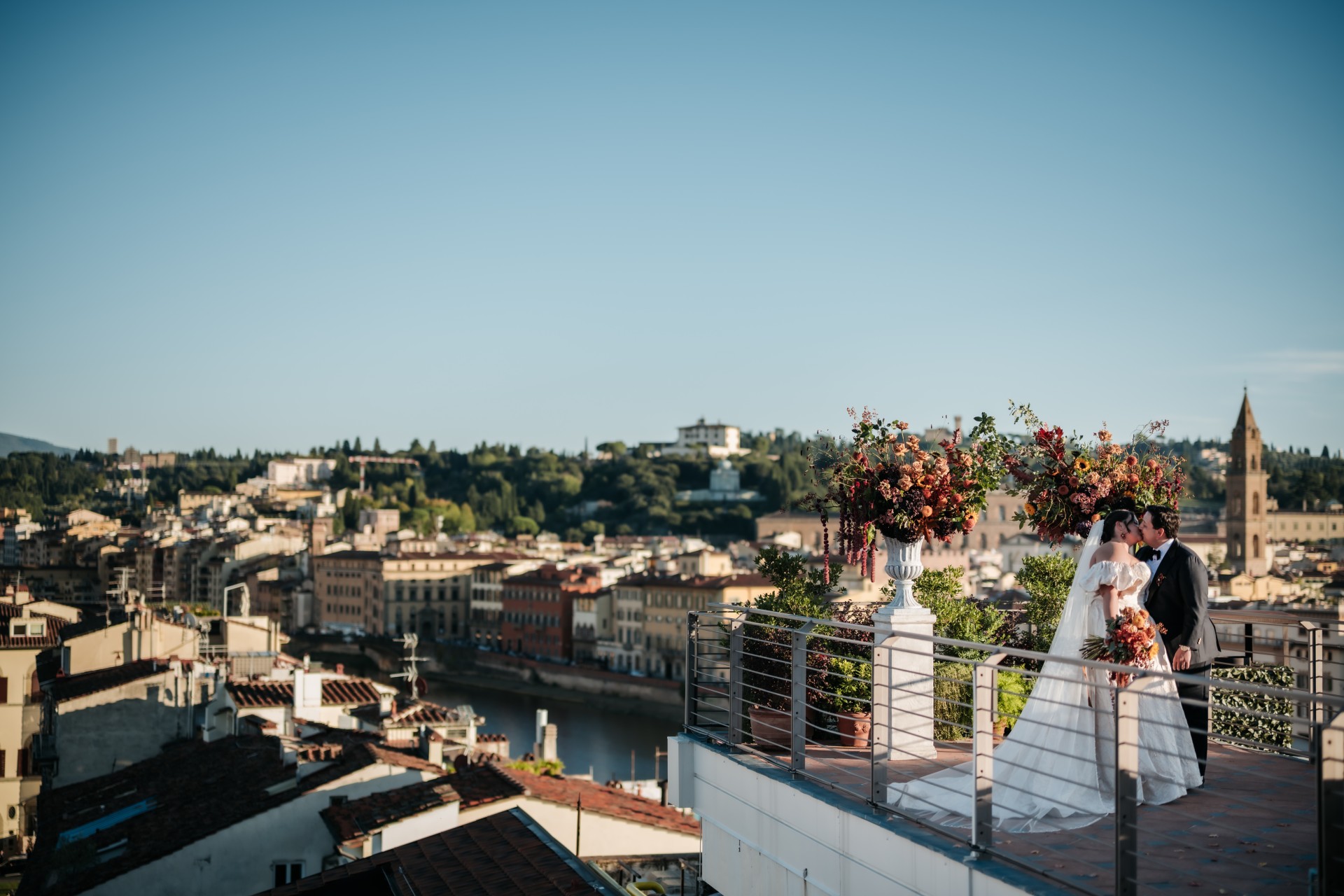 a couple standing on a balcony overlooking a city