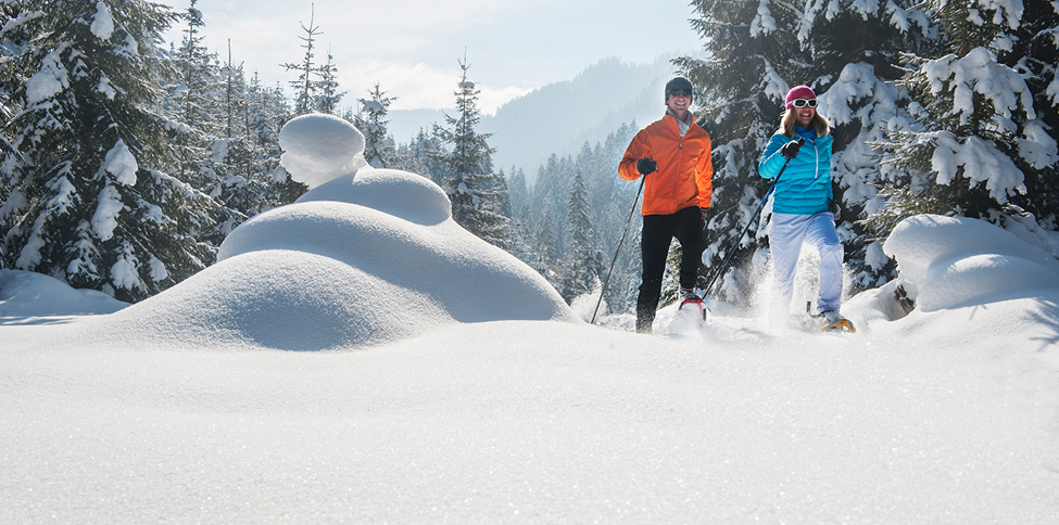 two people hiking through snow trail