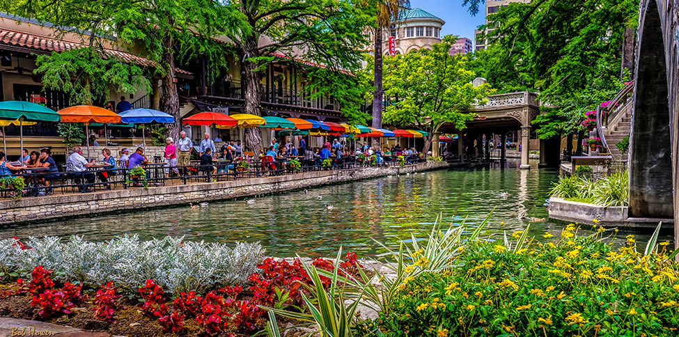 view of park area with a river and colorful umbrellas