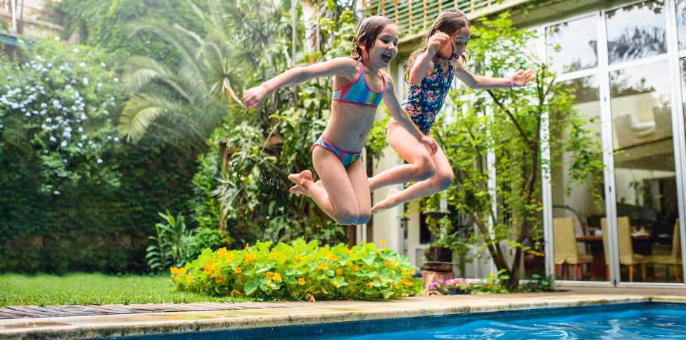 two girls jumping into pool