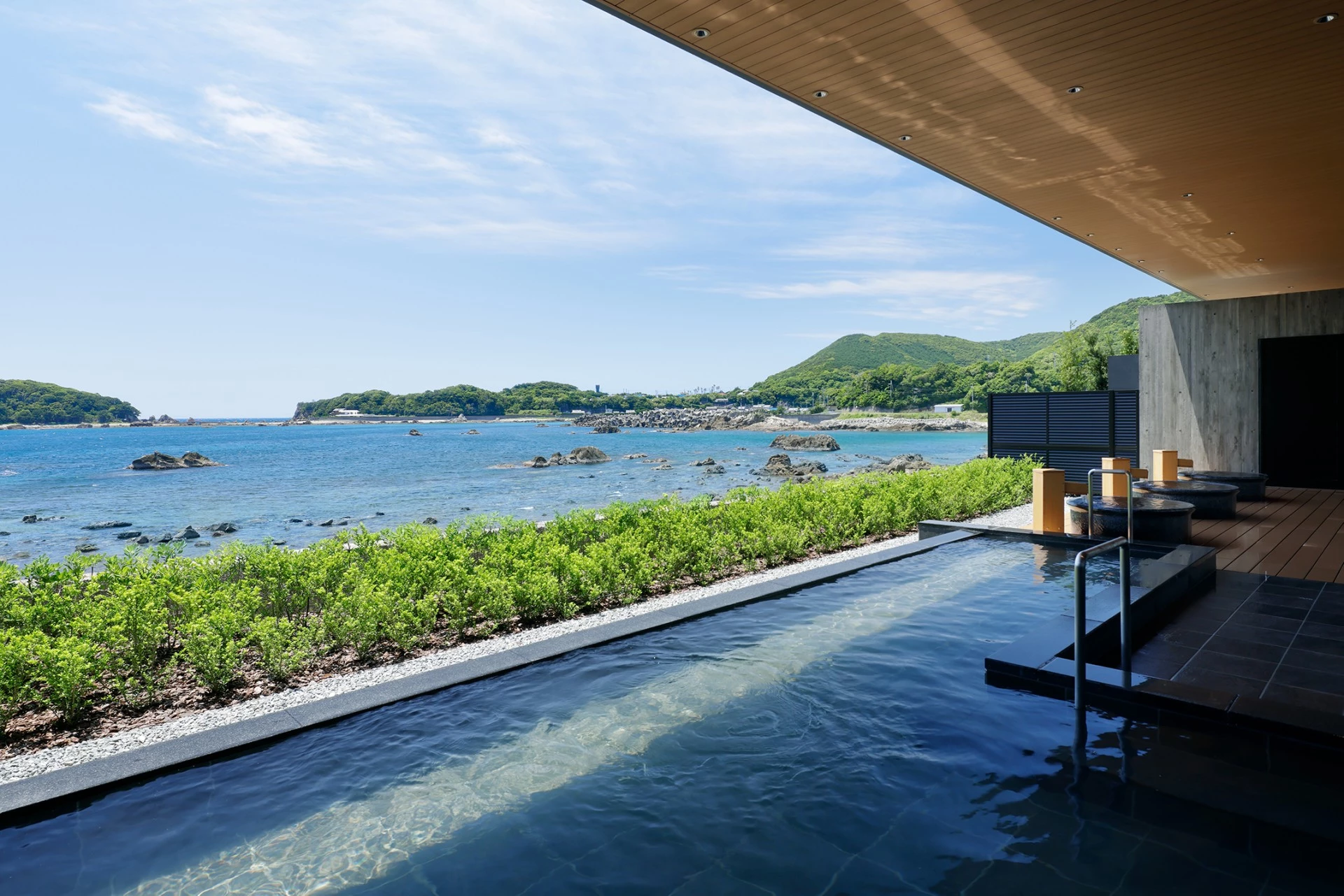 a pool with a view of the ocean and mountains in the background