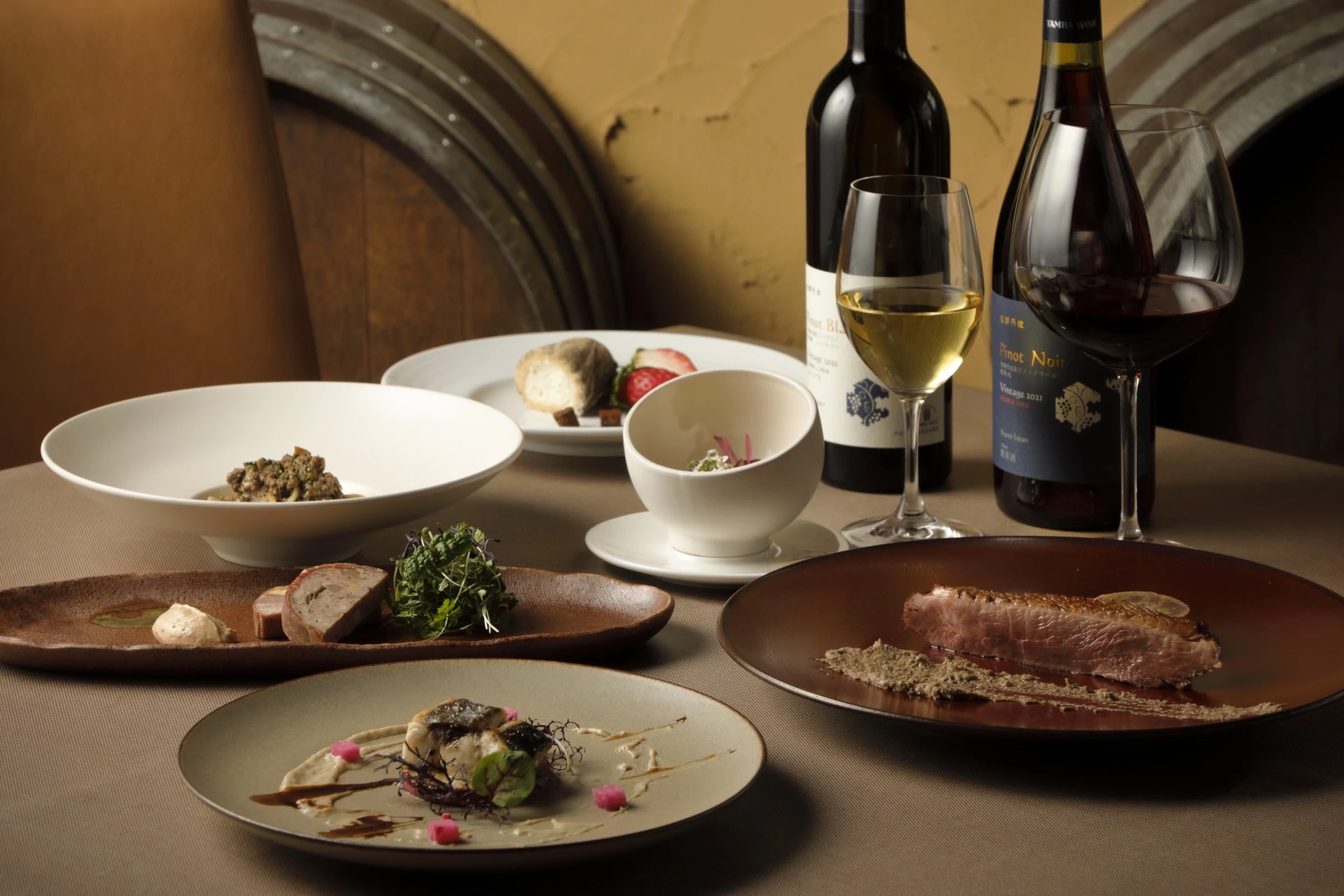 a table with plates of food and wine bottles