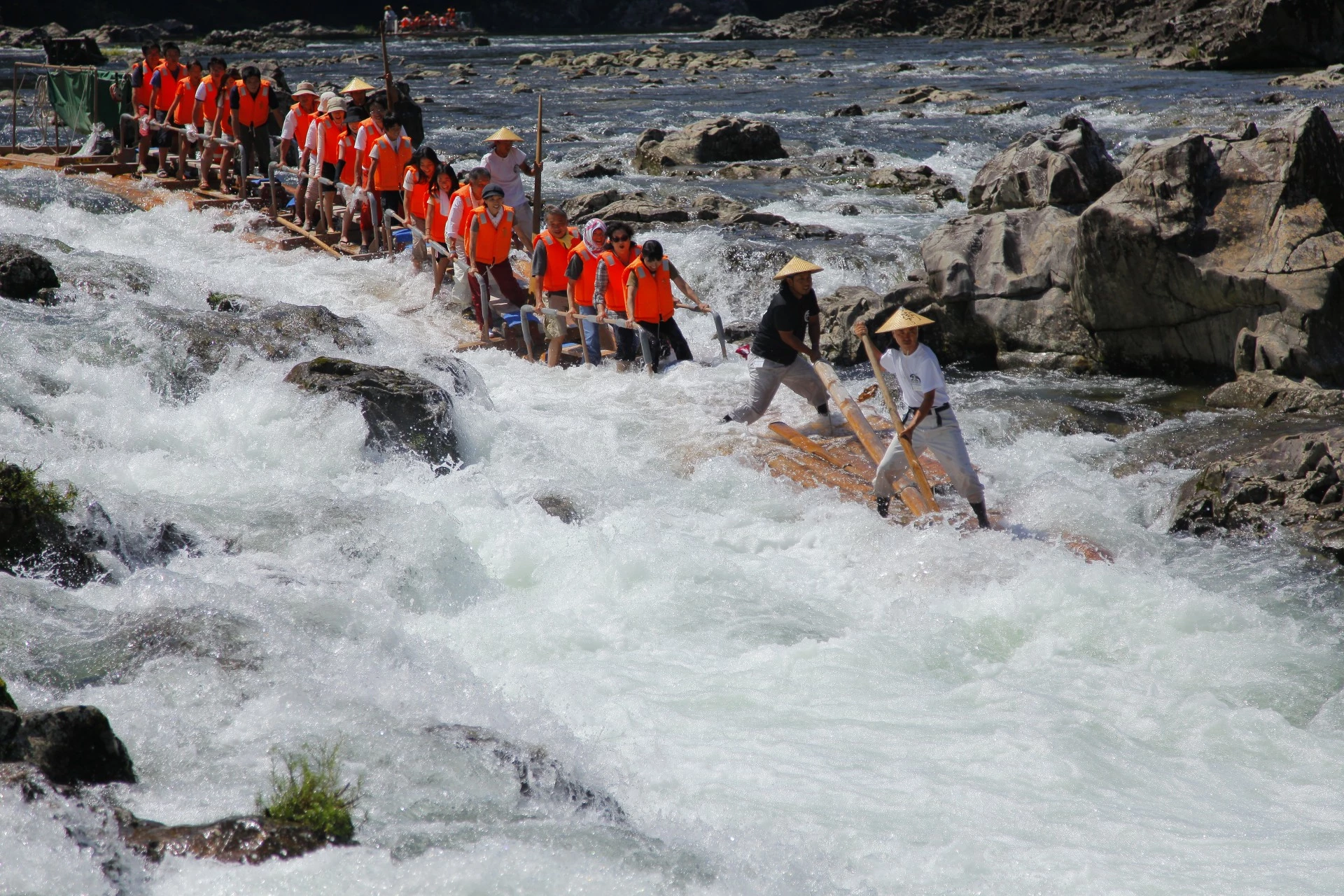 a group of people rowing a boat on a river