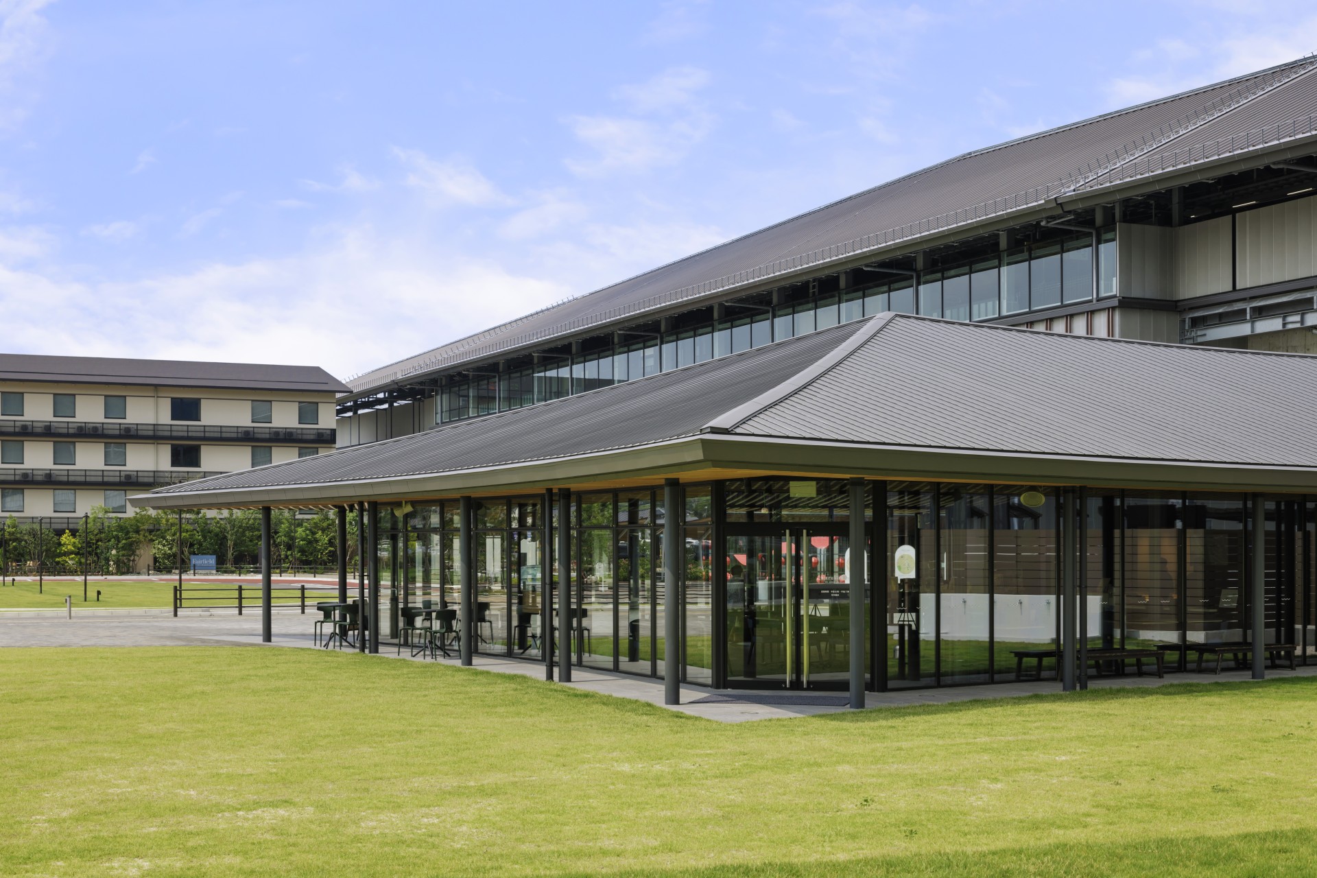 a building with glass walls and a lawn