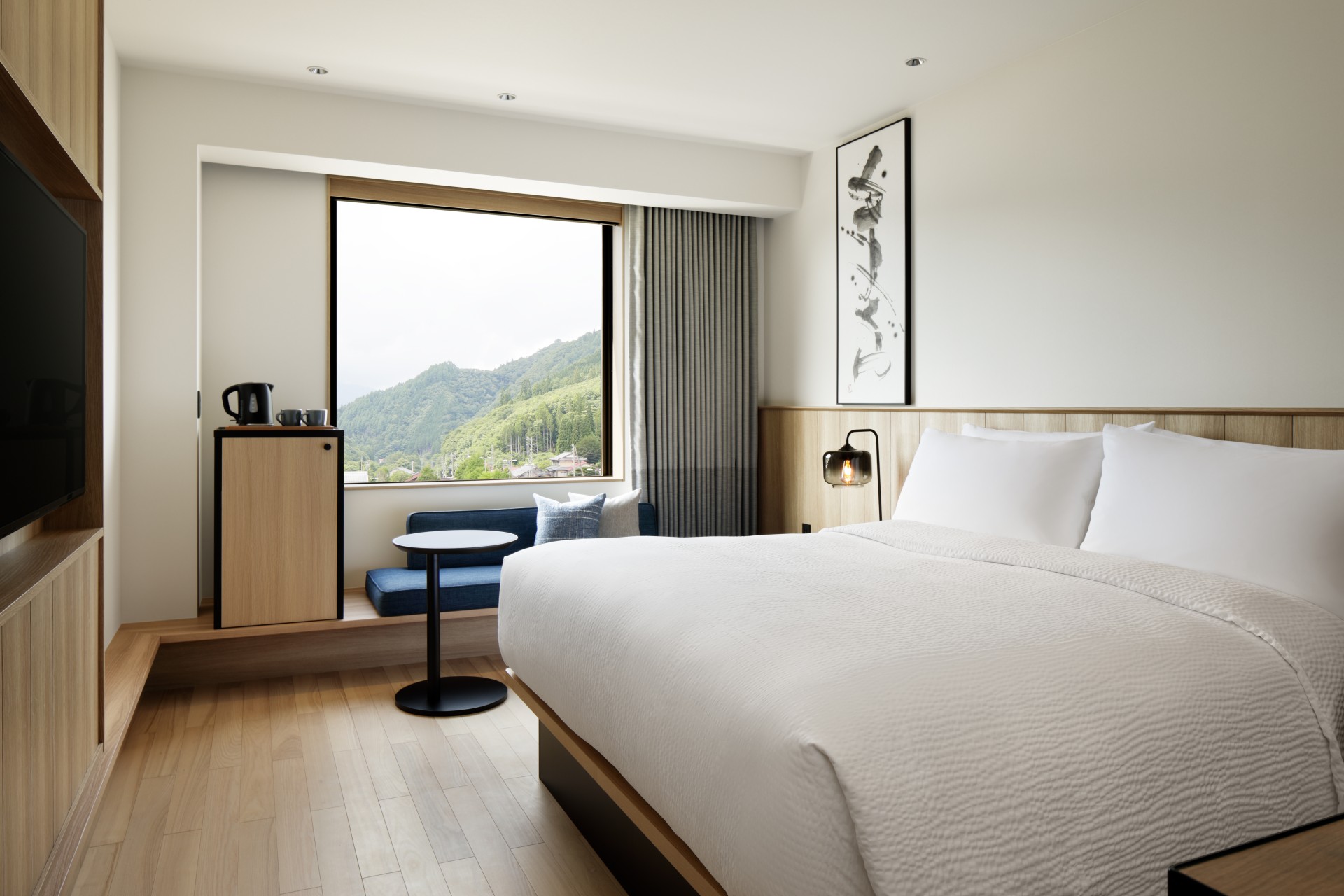 a room with a bed and a chair and a table