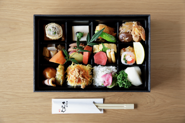 a box of food with chopsticks