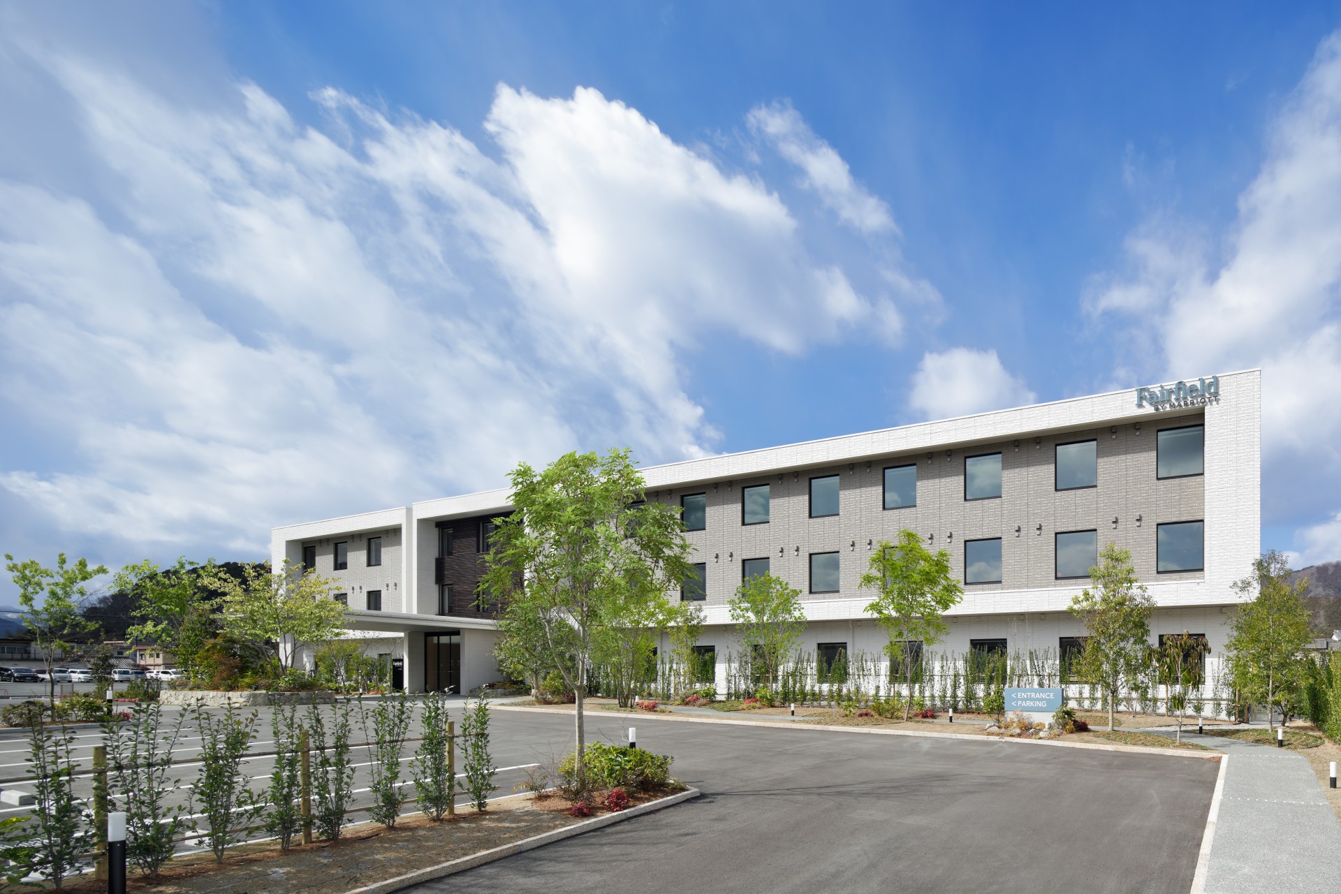 a building with trees and a parking lot