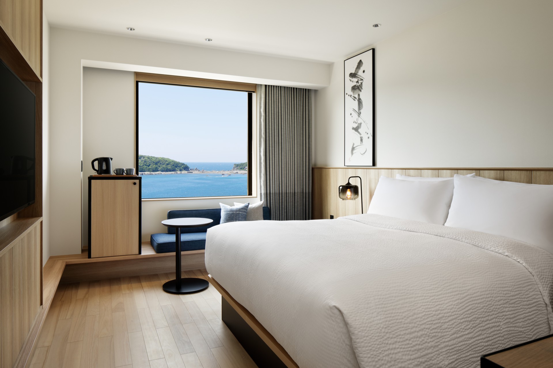 a room with a bed and a window overlooking the ocean