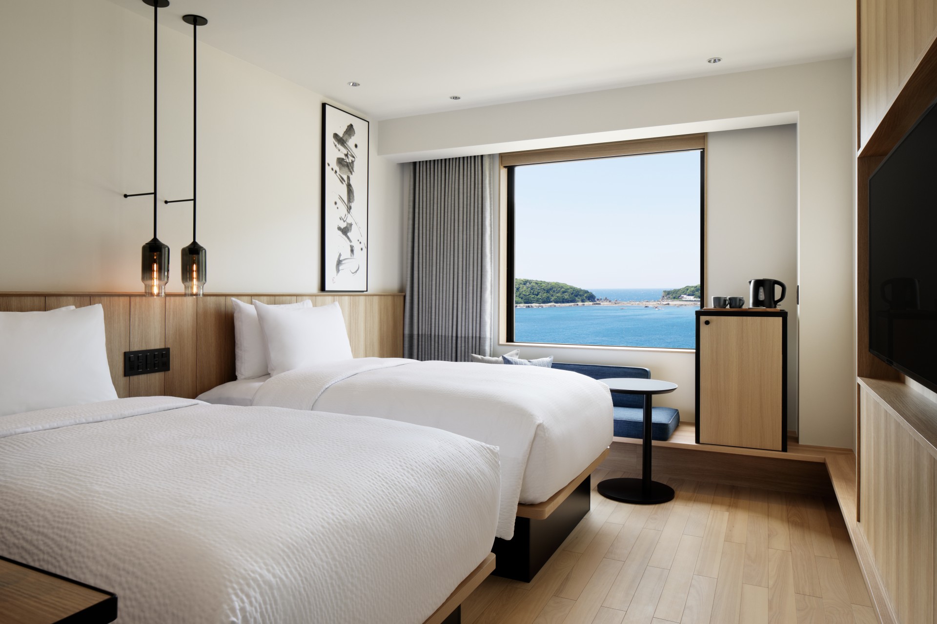a room with two beds and a window overlooking the ocean