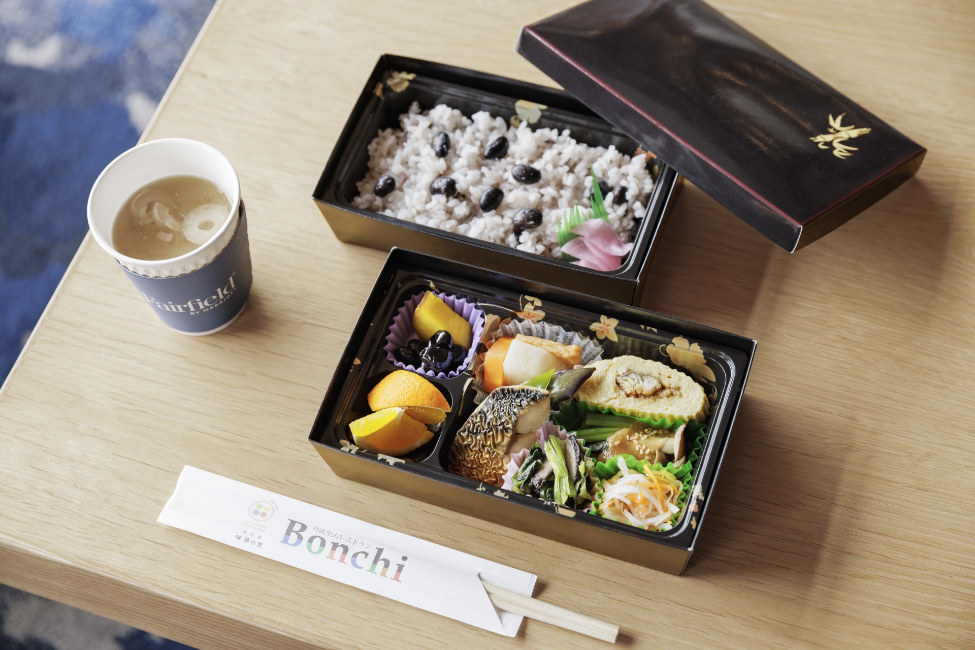 a lunch box with rice and vegetables on a table