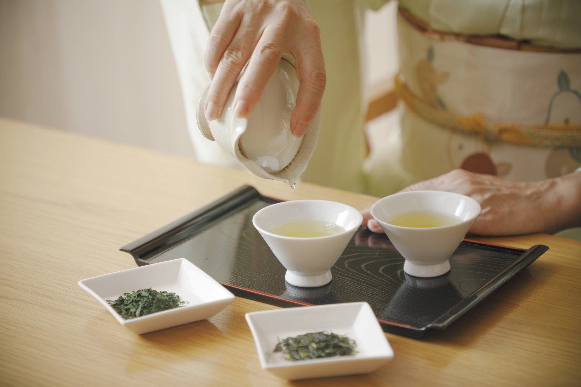 a person pouring liquid into small bowls